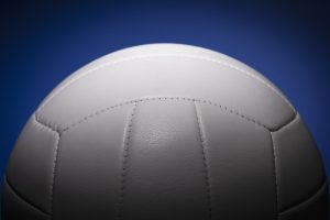 A white volleyball against a blue background.