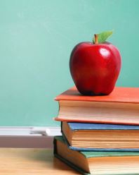 A picture of a red apple on top of books.