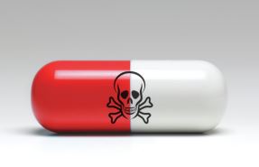 A pill-like object that is red one the left and white on the right; a skull and crossbones can be seen in the middle.