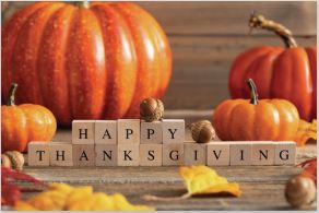 An image of some orange pumpkins, some yellow leaves, and words in blocks that read "Happy Thanksgiving."